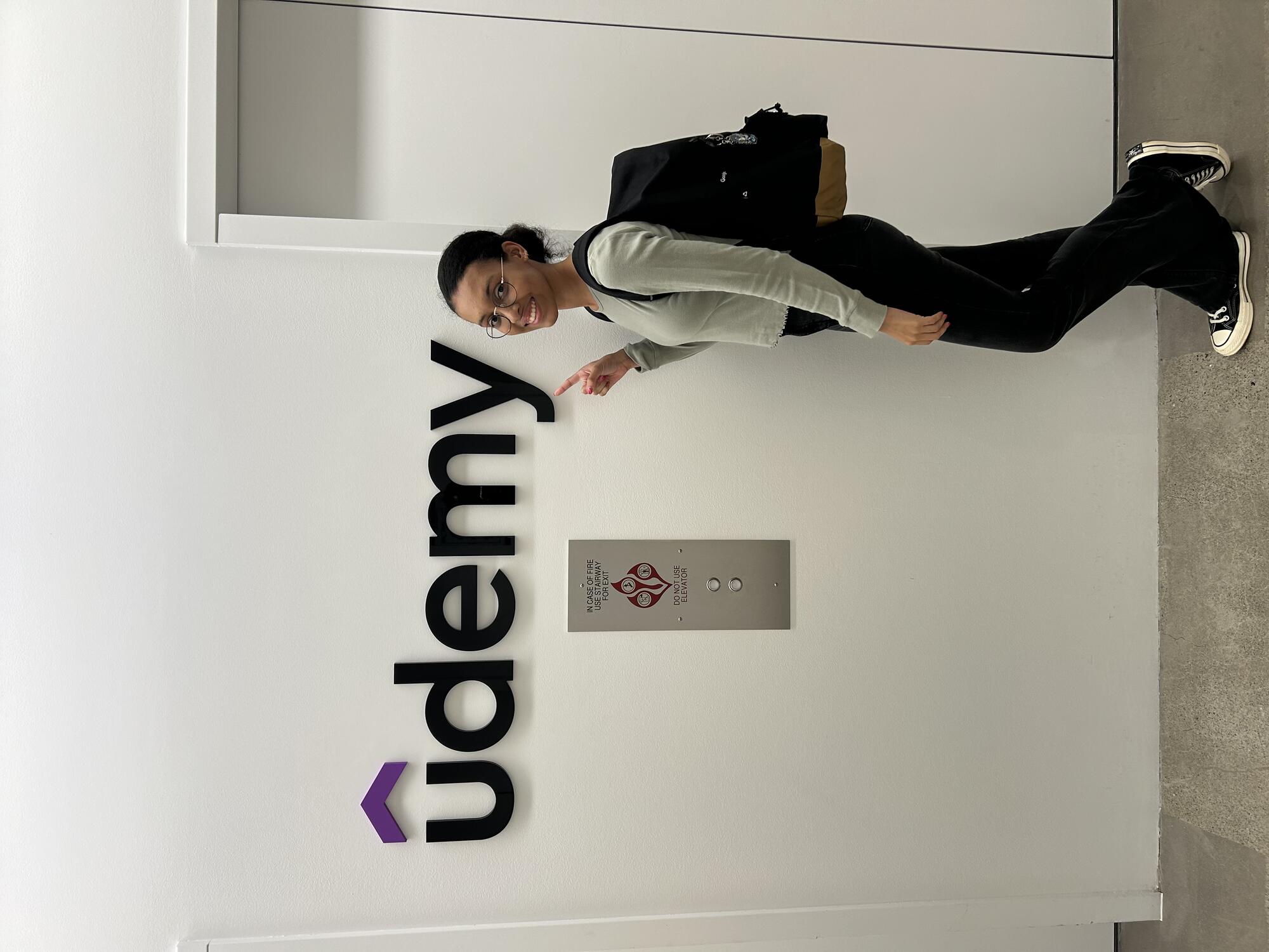 First day at Udemy holding welcome sign